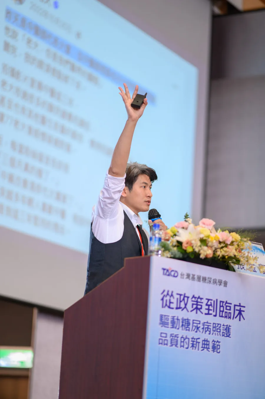 張益豪醫師於講台舉手與台下參與者互動