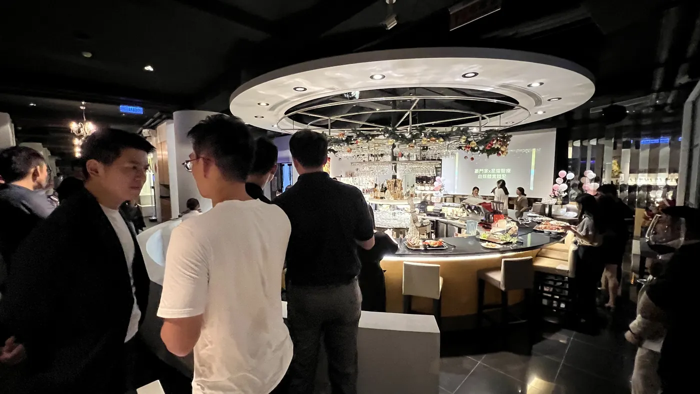 與會者站在圓形吧台邊交談