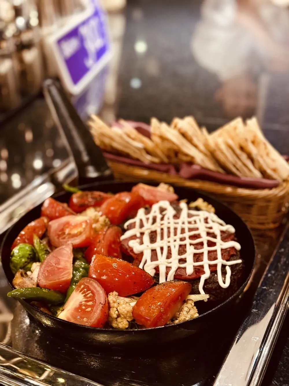 番茄沙拉淋上美乃滋，旁邊是一籃脆餅