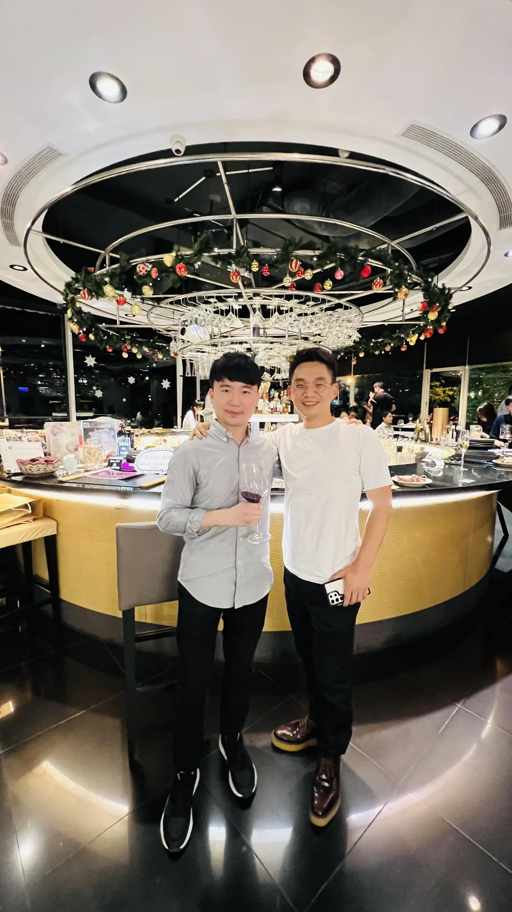 兩位與會者站在圓形吧台前合影