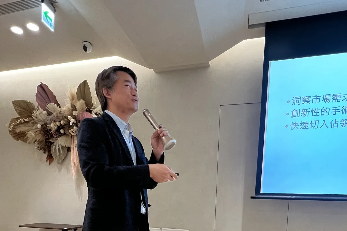 張聰麒醫師手持麥克風站在「洞察市場需求」投影片旁分享醫療品牌實戰