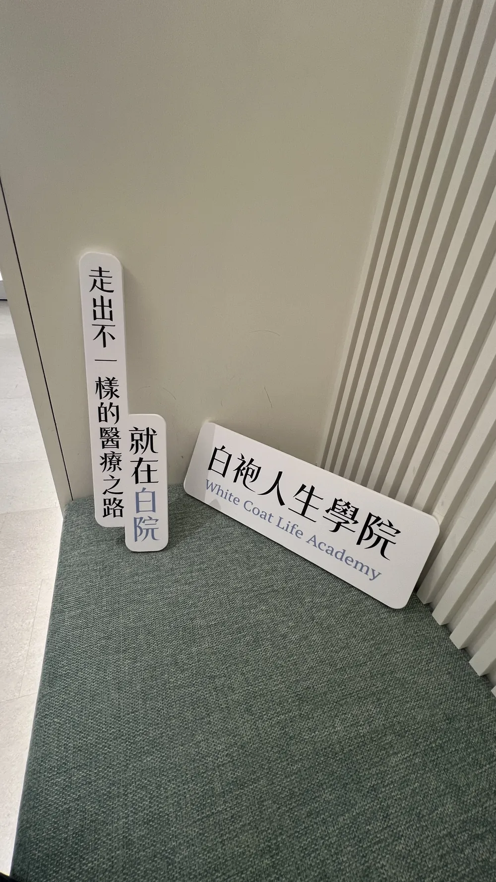 地上靠牆擺著三塊白袍人生學院立牌，分別寫著「走出不一樣的醫療之路」「就在白院」與「白袍人生學院 White Coat Life Academy」