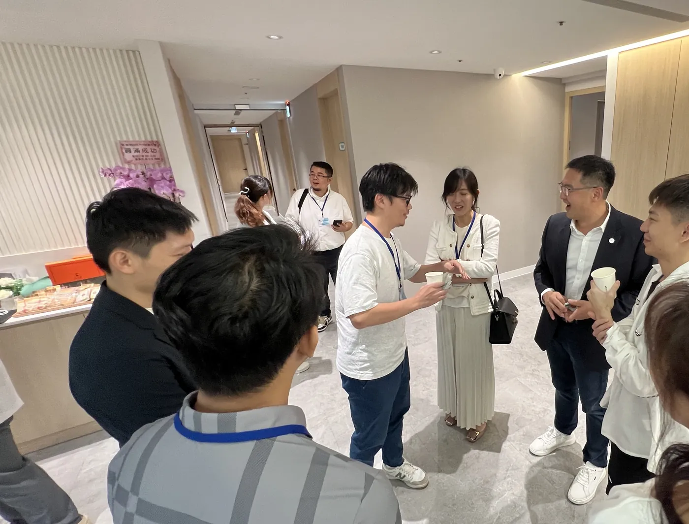 康博診所走廊上，一群醫師站著圍成一圈交談