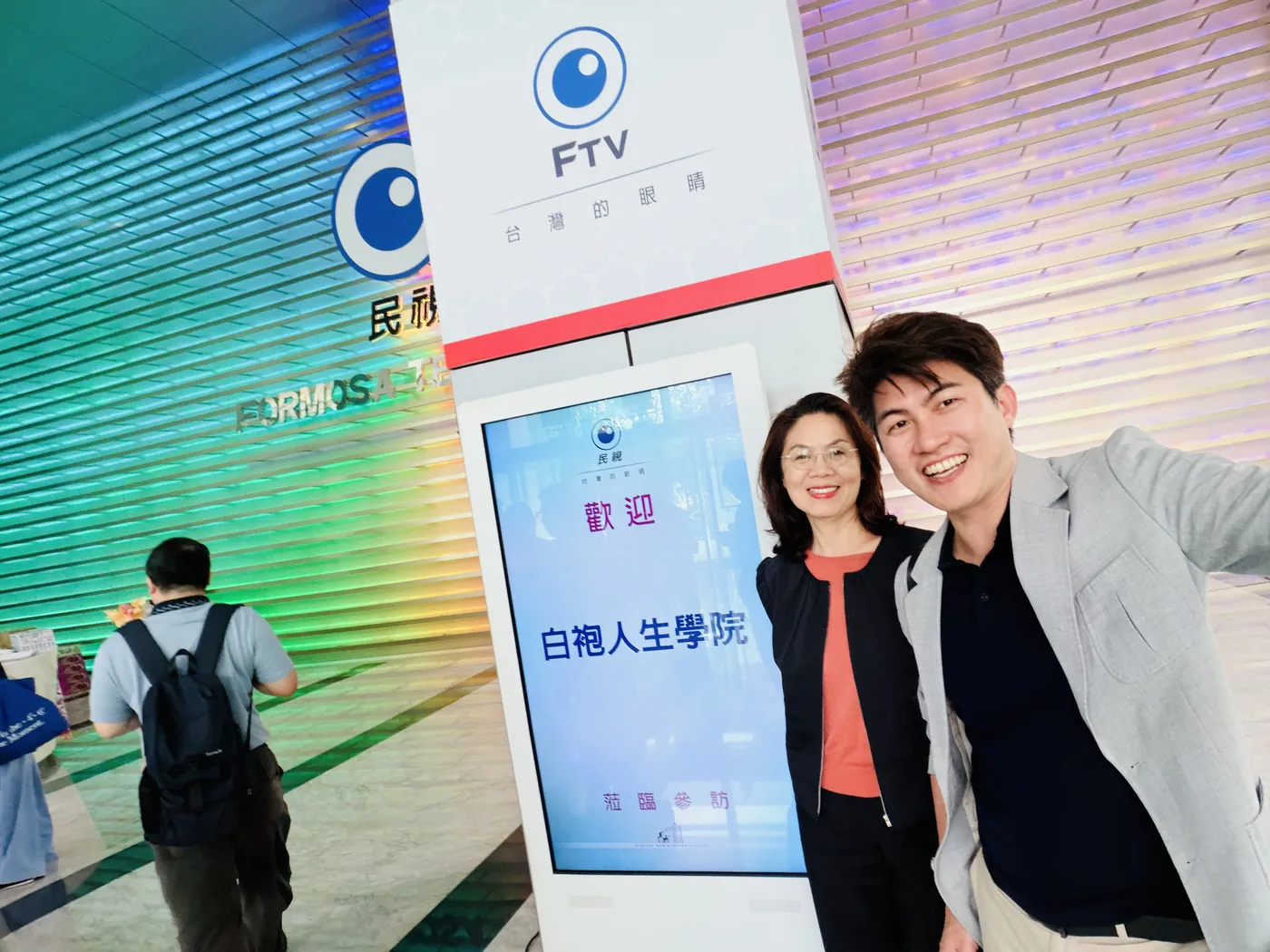 張益豪醫師與民視品牌事業部林香蘭執行長在大廳歡迎立牌前自拍
