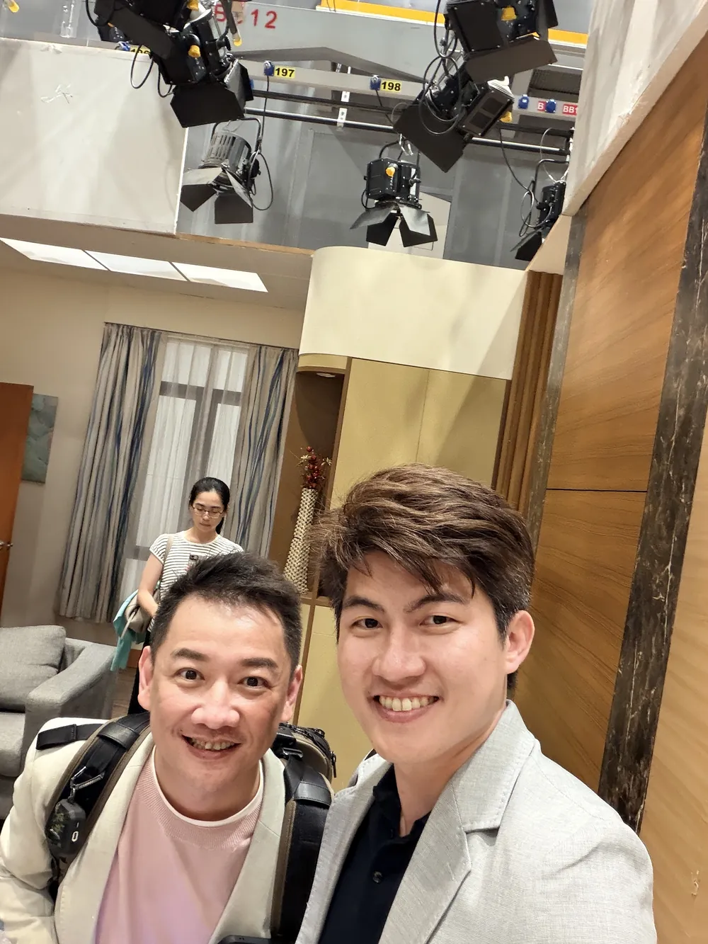 張益豪醫師與一位參訪醫師在客廳佈景前自拍，上方露出棚燈