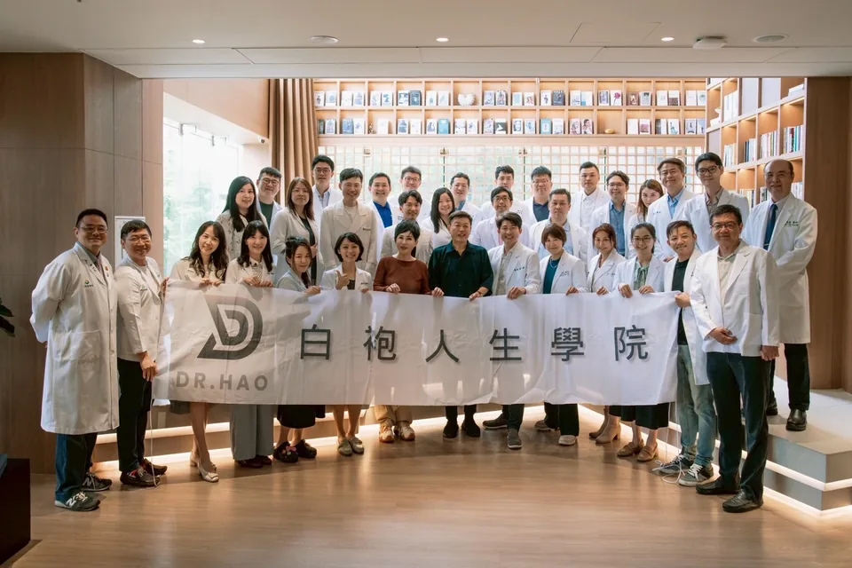白袍人生學院參訪馬光中醫信義旗艦店，參訪醫師與來賓在書牆前拉起學院布條合影